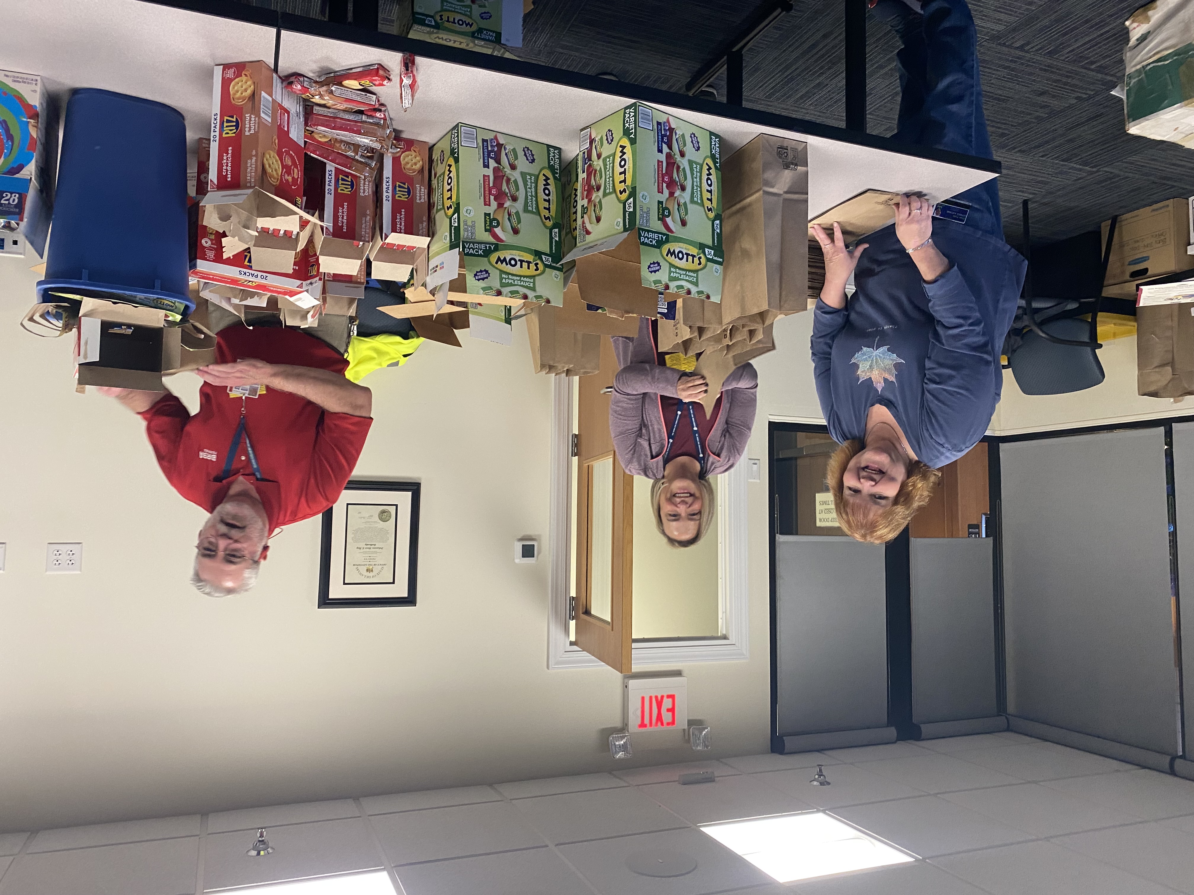 DRBA employees gather around a table of items to pack lunches