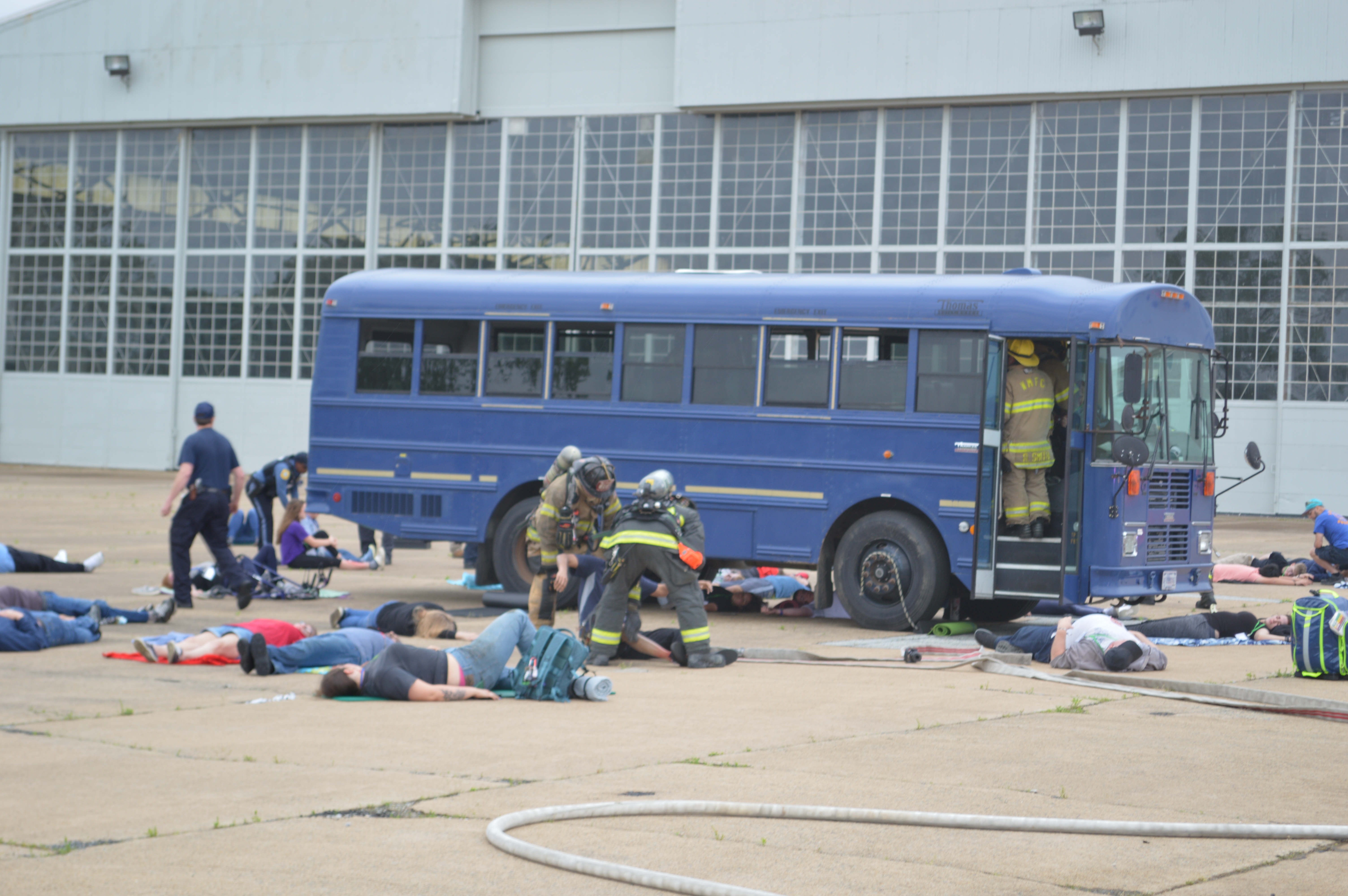 Old blue prop bus at ILG surrounded by firefighters practicing life-saving protocols