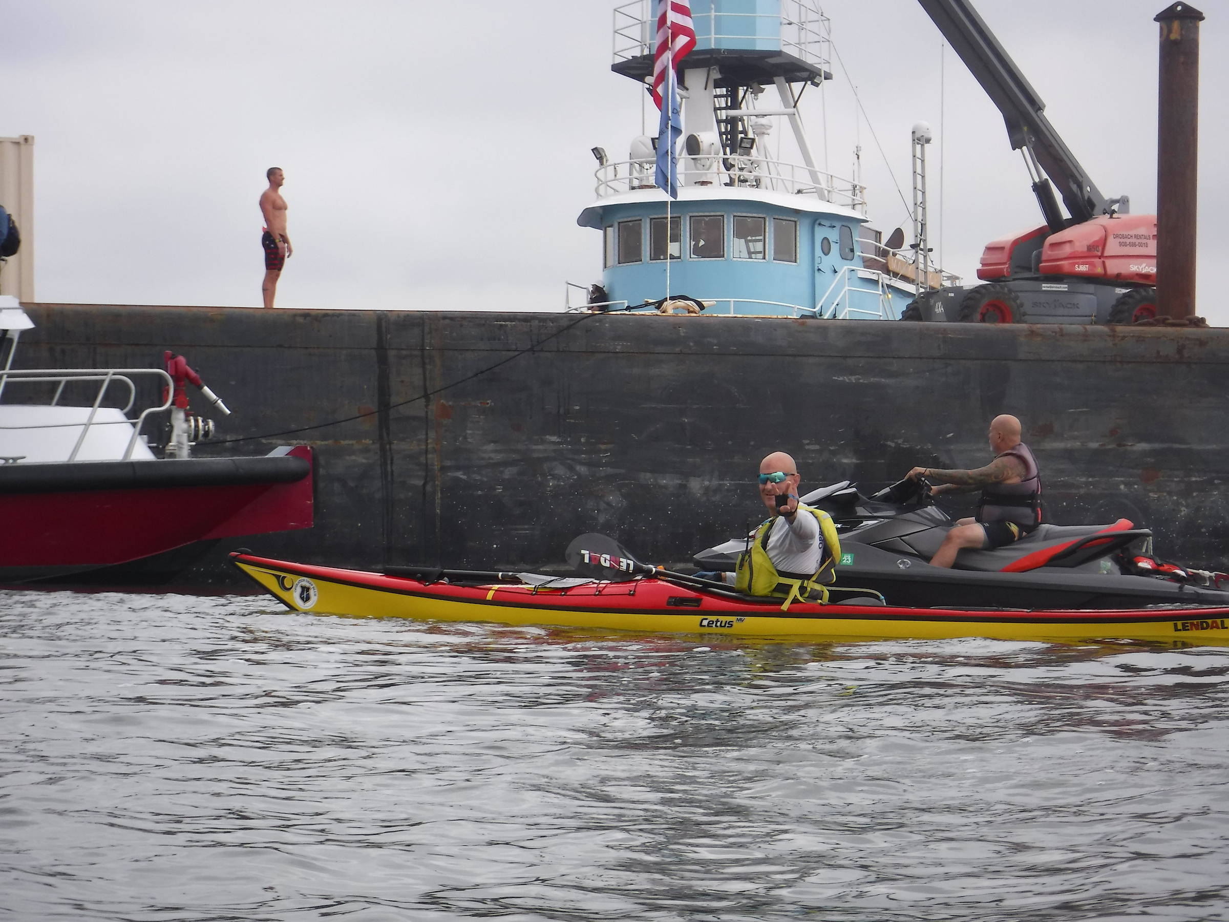Operation Deep Blue kayakers paddling past ship on NY harbor