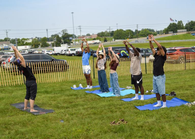 A group of five teens doing yoga with an instructor at the World Environment Day event at Veteran's Memorial Park