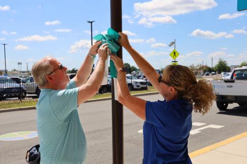 DRBA staff hang up teal bows outside of Wilmington Airport ILG