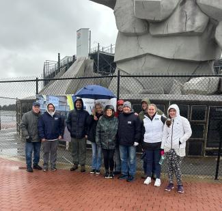 DRBA team stands in front of Miles the Monster statue at Dover Motor Speedway