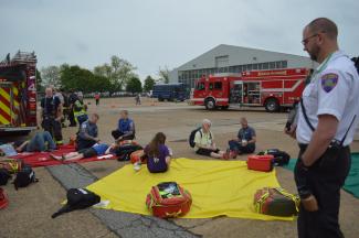 Paramedics gather around actors laying on the ground at ILG to practice life-saving protocols